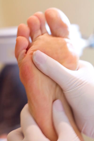 Massagem podal aplicada com os polegares na planta do pé